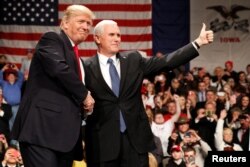 U.S. President-elect Donald Trump shakes hands with Vice President-elect Mike Pence (R) at the USA Thank You Tour event at the Iowa Events Center in Des Moines, Iowa, Dec. 8, 2016.