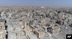 Una imagen de Raqqa tomada de un video de drone muestra decenas de edificios dañados en Raqqa, Siria, dos días después que las Fuerzas Democráticas Sirias dijeran que las operaciones militares para desalojar al Estado Islámico habían terminado. Oct. 19, 2017.