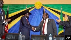 FILE - South Sudan's President Salva Kiir, left, shakes hands with rebel leader and former vice president Riek Machar, right, after signing an agreement at the end of talks in Arusha, Tanzania, Jan. 21, 2015.