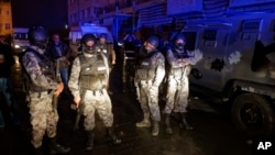 Jordanian security forces stand next to their armored vehicle at the scene next to Karak Castle, during an ongoing attack, in the central town of Karak, about 140 kilometers (87 miles) south of the capital Amman, Jordan, Dec. 18, 2016.