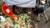 People place flowers at a makeshift memorial near the site, to pay tribute to the victims of the attack on the Holey Artisan Bakery and the O'Kitchen Restaurant, in Dhaka, Bangladesh, July 5, 2016.