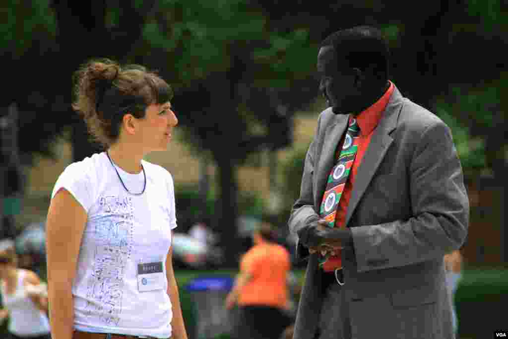 A South Sudanese man speaks with a project staff member at the "One Million Bones" installation on the National Mall, Washington, D.C, June 8, 2013. (Jill Craig/VOA)