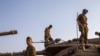 FILE - Israeli soldiers work on tanks in the Israeli controlled Golan Heights near the border with Syria, not far from Lebanon border, July 28, 2020. 