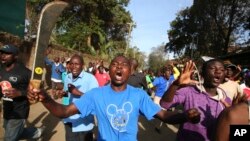 Wani mai goyn bayan 'yan hamayya dauke da adda a unguwar talakawa da ake kira Kawangware dake birnin Nairobi.
