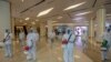 Cleaners in hazmat suits demonstrate disinfection as workers remodel a display window at Siam Paragon, an upmarket shopping mall, in Bangkok, Thailand, May 14, 2020. 