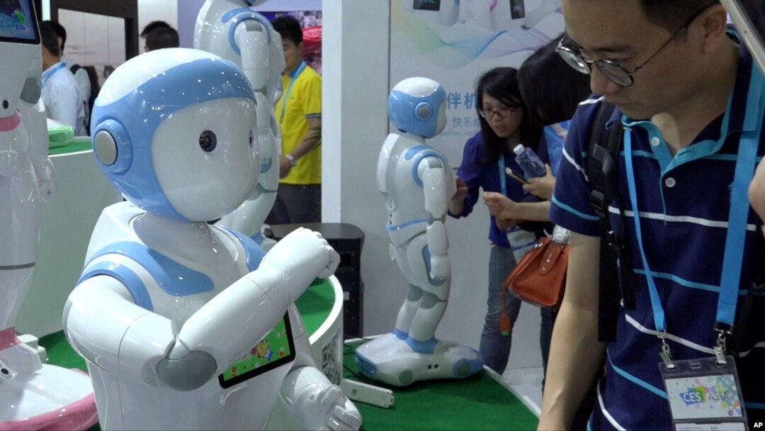 In this image taken from video, visitors look at iPal robots during the Shanghai CES electronic show in Shanghai, China, June 8, 2017. More than 50 companies are showcasing a new generation of robots at this week's Shanghai CES electronics show, most of which serve as companions at home, or butlers in shopping malls.