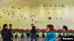 在北京举行的2019年世界园艺博览会上，参观者们走过一堵墙上，墙上挂着一幅地图，上面画着“一带一路”沿线国家的牡丹品种。(4月29日)