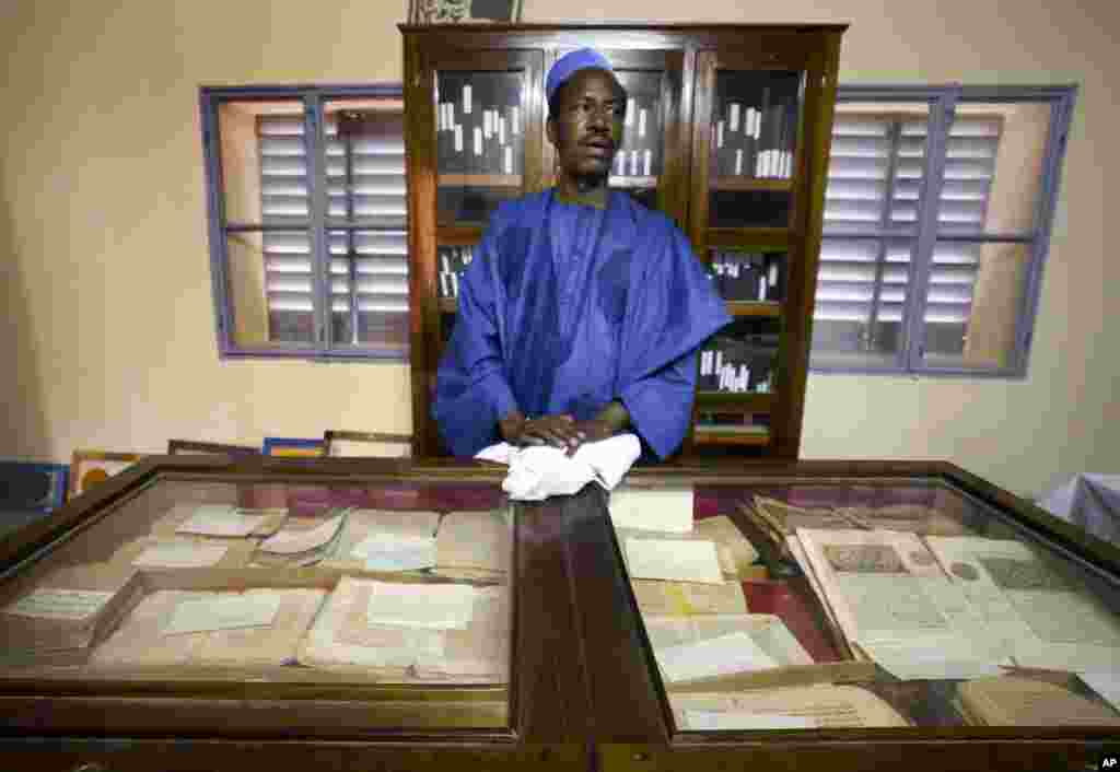 This March 16, 2004 photo shows an unidentified worker looking after some of the 20,000 preserved ancient Islamic manuscripts which rest in air-conditioned rooms at the Ahmed Baba Institute in Timbuktu, Mali.