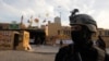Members of Iraqi security forces are seen in front of U.S. Embassy during a protest to condemn air strikes on bases belonging to Hashd al-Shaabi (paramilitary forces), in Baghdad, Iraq January 1,…
