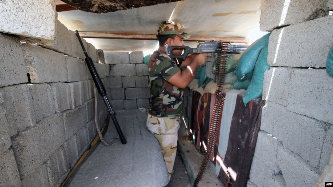 FILE - A member of the allied Iraqi forces, which consists of the Iraqi army and fighters from the Popular Mobilization units, guards a lookout point during clashes with Islamic State fighters on the outskirts of Fallujah, in Iraq's Anbar province, Aug. 13, 2015