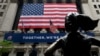 FILE - A man passes the building before the opening bell at the New York Stock Exchange on Wall Street in New York City, May 26, 2020.