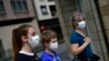 FILE - A family wearing face mask to protect of the coronavirus go for a walk, in Pamplona, northern Spain, Sunday, April 27, 2020.