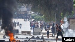 Supporters of Islamist group Ansar al-Sharia clash with riot police at Hai al-Tadamon in Tunis, May 19, 2013. 