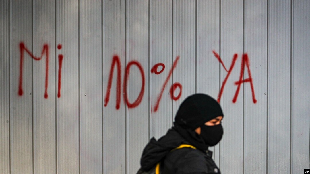 Una mujer con mascarilla pasa delante de un grafiti contra las Administradoras del Fondo de Pensiones en Santiago, Chile, el 22 de julio de 2020.