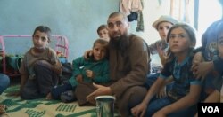 Abu Osama, the main character in the documentary "Of Fathers and Sons," is surrounded by his children in his house in northern Syria. (Kahtan Hasson for VOA)