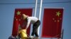 Workers hang up Chinese flags on a street ahead of the 70th founding anniversary of People's Republic of China in Kunming, Yunnan province, China, Sept. 22, 2019. 