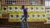 A man walks past election posters for incumbent President Yoweri Museveni in Kampala on Feb. 11, 2016.