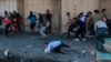 Anti-government protesters run for cover while security forces fire live ammunition in the air to disperse protesters, during ongoing protests, in Khilani Square, Baghdad, Nov. 11, 2019.