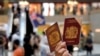 英国国民海外护照2021年1月31日开始，成为香港人出离压迫的单程车票。图为一名香港示威者在反对港版国安法的抗议中手举英国国民海外护照。（路透社2020年6月1日资料照）