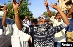 FILE - Demonstrators chant slogans as they march along the street during anti-government protests in Khartoum, Sudan, Dec. 25, 2018.
