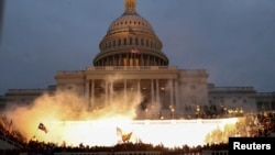 ARCHIVO: Se ve una explosión causada por una munición policial mientras los partidarios del presidente de Estados Unidos, Donald Trump, se reúnen frente al edificio del Capitolio en Washington, EEUU, el 6 de enero de 2021.