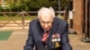 A handout photo taken in April 2020, and released by the Maytrix Group in London on April 14, 2020, shows World War Two (WWII) veteran 99-year-old Captain Tom Moore walking in his garden in Marston Moretaine, north of London, to raise money for Britain's 
