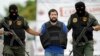 Daniel Barrera Barrera, one of Colombia's most wanted drug lords, whose alias is “El Loco” is escorted in a flak jacket by National Guard troopers as he is deported to Colombia from Venezuela, Nov. 14, 2012.