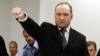Norwegian mass killer Anders Behring Breivik gestures as he arrives at the court room in Oslo Courthouse August 24, 2012. 