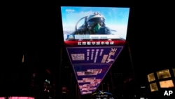 資料照片：北京一個戶外屏幕上顯示的一名中國戰鬥機飛行員在演習中豎起大拇指。(2023年4月10日)