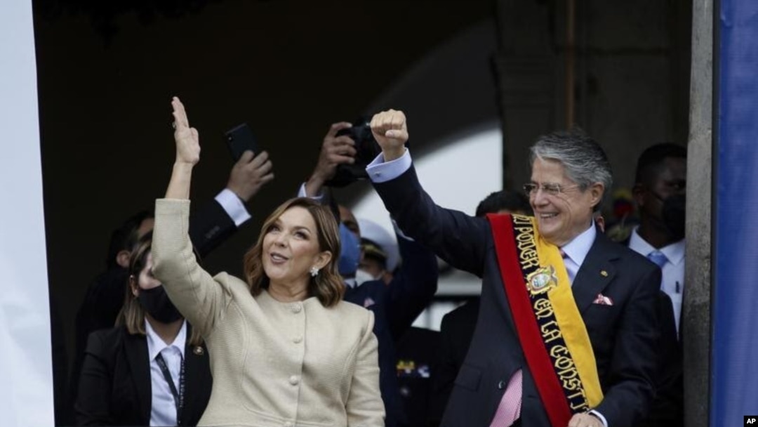 El nuevo presidente de Ecuador, Guillermo Lasso, derecha, y la primera dama María de Lourdes de Lasso saludan a la multitud el lunes 24 de mayo de 2021 desde el balcón del Palacio Carondelet, en Quito.