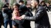 A Turkish man helps a Syrian woman carrying a wounded Syrian girl to a hospital in Kilis, Turkey, Feb. 15, 2016.