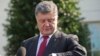 Ukrainian President Petro Poroshenko checks his watch while speaking to members of the media outside the West Wing of the White House, following his meeting with President Barack Obama, Sept. 18, 2014.