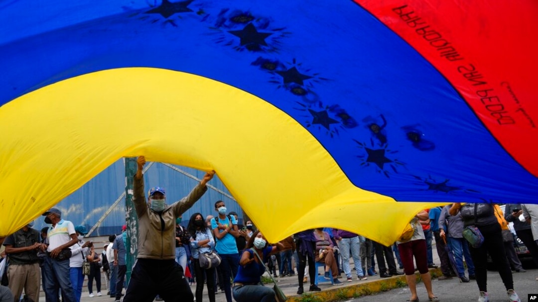 Simpatizantes opositores ondean una bandera venezolana en un mitin el primer día de la campaña de 2021, en Caracas, el 28 de octubre de 2021.