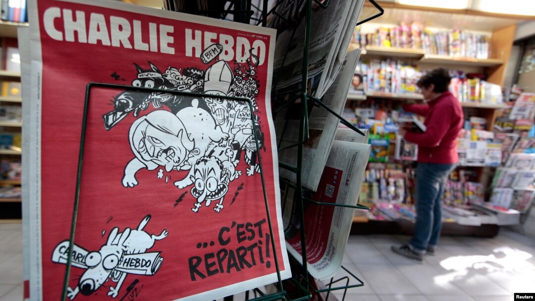 FILE - The front page of the new issue of satirical French weekly Charlie Hebdo entitled "C'est Reparti" ("Here we go again"), is displayed at a kiosk in Nice, Feb. 25, 2015. 