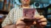 A merchant counts Syrian pound notes at the Bzourieh market in the center of the Syrian capital Damascus, Sept. 11, 2019.