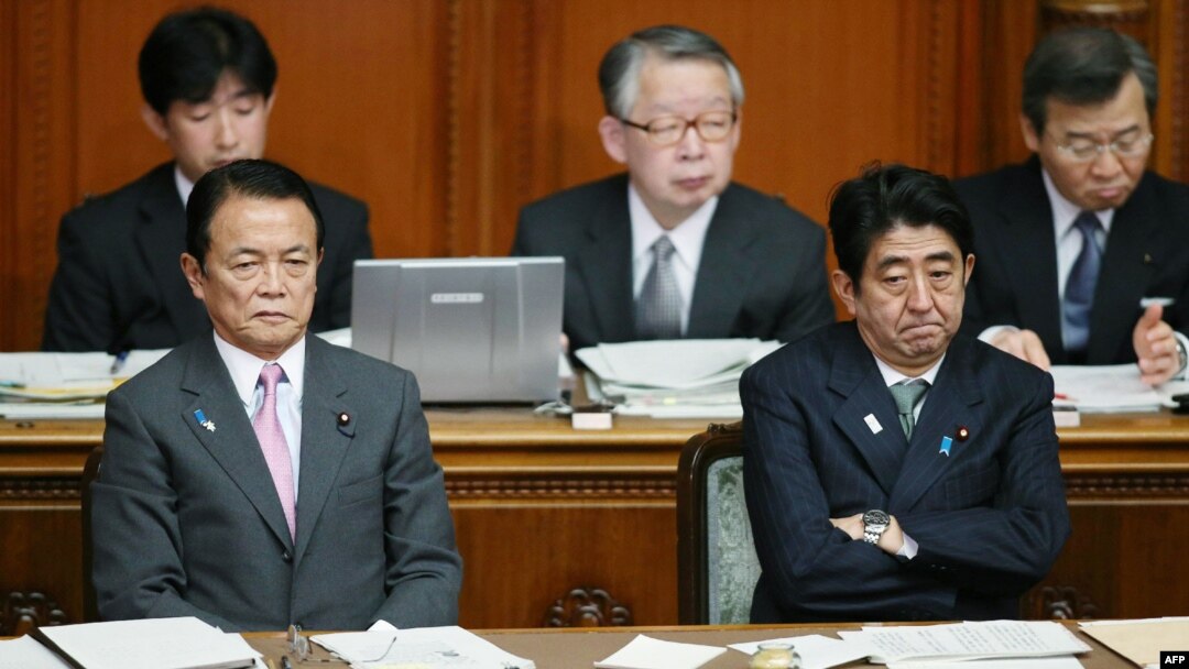 Japanese Prime Minister Shinzo Abe (R) and Finance Minister Taro Aso (L) show their sour faces at the Upper House's plenary session at the National Diet in Tokyo, February 6, 2013.