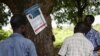 Residents of Lukodi village, where dozens were killed in 2004 by the Lord's Resistance Army, react as they listen to the International Criminal Court's sentence of Dominic Ongwen, on radio in Lukodi, Uganda, May 6, 2021. 