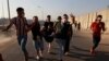 Men carry an injured demonstrator during a nationwide anti-government protests in Baghdad, Iraq, Oct. 3, 2019.