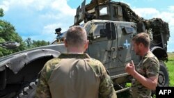 烏克蘭第37海軍陸戰旅一名代號“斯巴達”的營長(左)在頓涅茨克前線附近與一名海軍陸戰隊員交談。(2023年6月30日)
