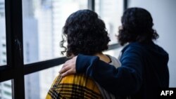 Saudi sisters Rawan (in yellow), 18, and Reem, 20, (both using adopted aliases) stand next to each other during an interview with AFP in Hong Kong, Feb. 22, 2019.