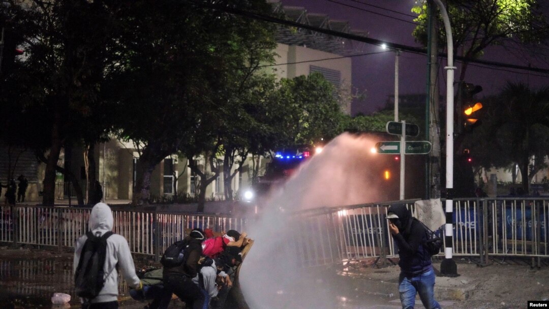 Manifestantes se enfrentan a la policía en Barranquilla, Colombia, el 12 de mayo, tras varios días de protestas por reclamos sociales y de derechos humanos.