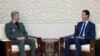 This photo released by the Syrian official news agency SANA, shows Syrian president Bashar al-Assad, right, meeting with Iran's defense minister Amir Hatami, in Damascus, Syria, Aug. 26, 2018. 