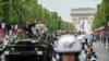FILE - France's President Emmanuel Macron and French Armies Chief Staff General Francois Lecointre review troops before the start of the Bastille Day military parade down the Champs-Elysees avenue in Paris, July 14, 2019. 