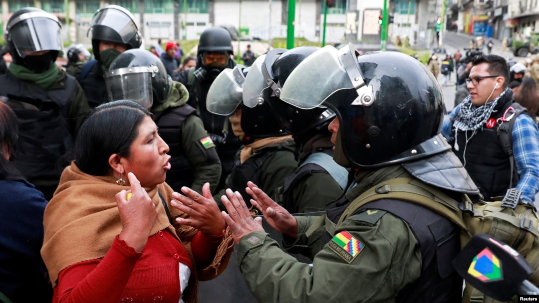 Una mujer discute con un miembro de las fuerzas de seguridad durante los enfrentamientos entre miembros de las fuerzas de seguridad y simpatizantes del ex presidente boliviano Evo Morales en La Paz, Bolivia, 13 de noviembre de 2019. 