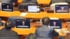 Legisladores surcoreanos miran pantallas que muestran una transmisión del discurso del presidente Yoon Suk Yeol sobre el levantamiento de la ley marcial, en la Asamblea Nacional en Seúl, el 4 de diciembre de 2024.