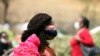 A woman wears a protective face mask following the closure of Wuse market for failing to adhere to COVID-19 prevention protocols in Abuja