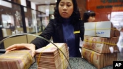 越南銀行職員從客戶手上接收現金存款(資料圖片)
