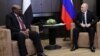 FILE - Russian President Vladimir Putin talks with Sudan's President Omar al-Bashir during their meeting in the Black Sea resort of Sochi, Russia, Nov. 23, 2017.