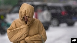 一位妇女在暴风雪中的北京街道上行走。