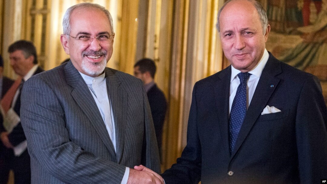 FILE - French foreign minister Laurent Fabius, right, poses for photographers with his Iranian counterpart Jawad Zarif prior to their meeting at the Quai d'Orsay in Paris, France, Nov. 5, 2013. 